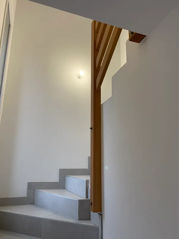 Montant du garde-corps fixé contre le mur